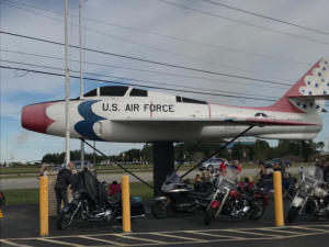 Motorcycles parked beneath the F-84F at Post 490